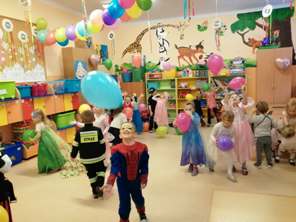 Dzieci w strojach karnawałowych bawią się w sali lekcyjnej